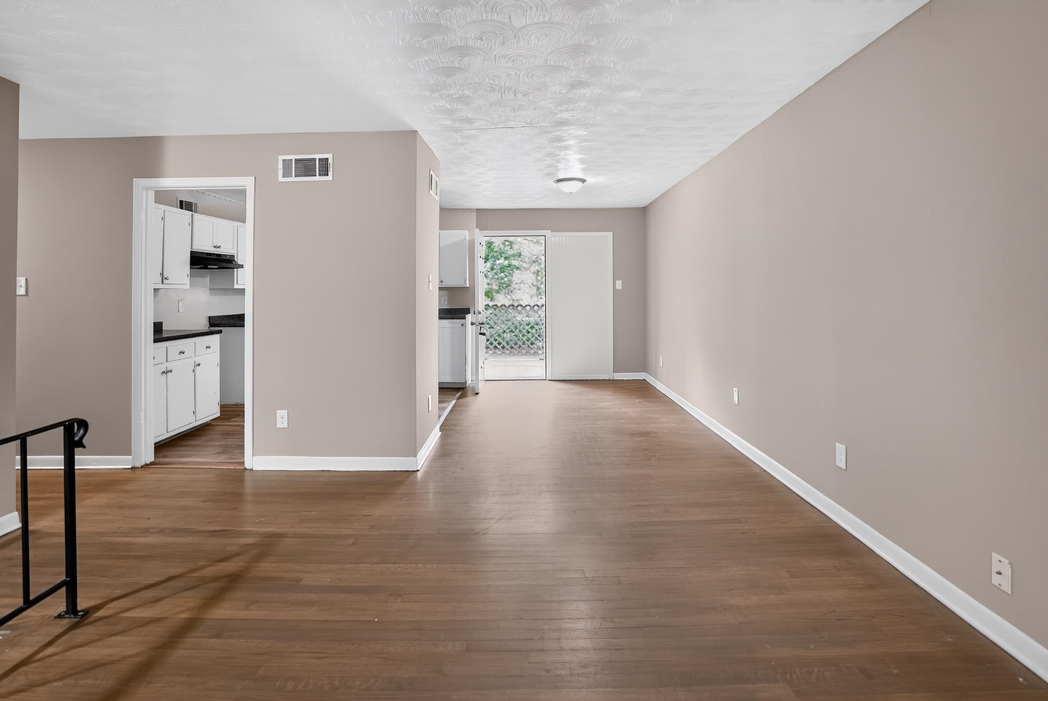 3391 South Perkins Road Memphis, TN 38118 - Photo 4 of 16 Spacious living area featuring wood-finish flooring, neutral wall paint, and white baseboards