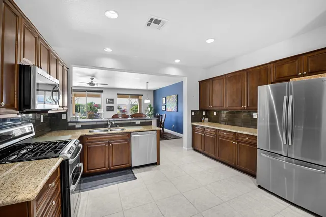 a kitchen with stainless steel appliances granite countertop a refrigerator and a stove top oven