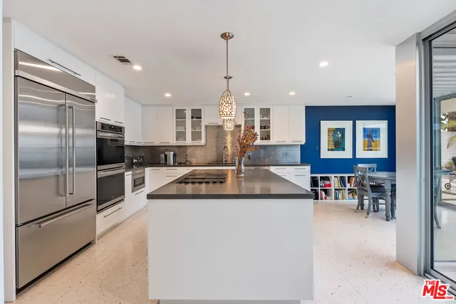 a kitchen with stainless steel appliances granite countertop a refrigerator a stove and a sink