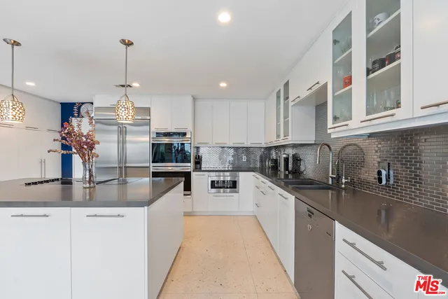 a kitchen with stainless steel appliances granite countertop a sink a stove and a granite counter tops