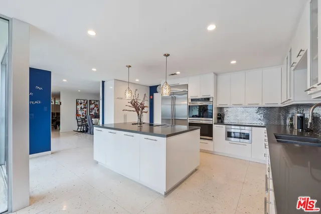 a kitchen with stainless steel appliances kitchen island granite countertop a refrigerator and a stove top oven