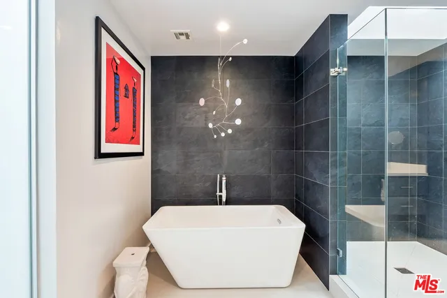 a bathroom with a white bathtub and shower