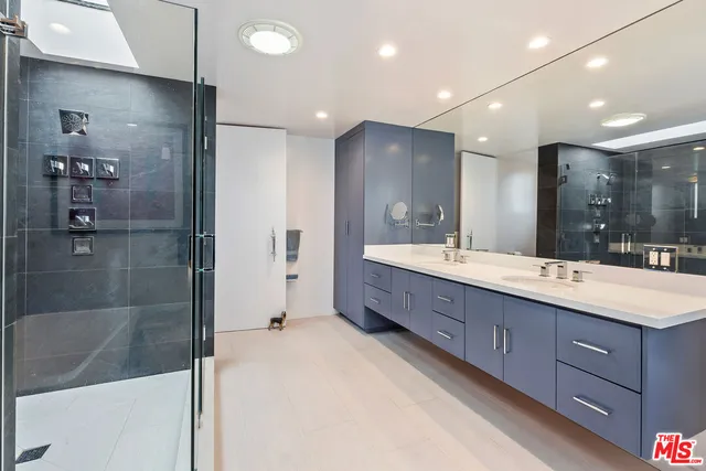 a bathroom with a double vanity sink mirror and shower