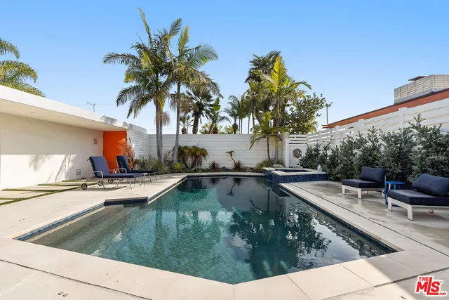 a view of a swimming pool with a patio and a yard