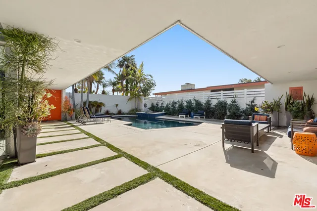 a view of swimming pool with outdoor seating and plants