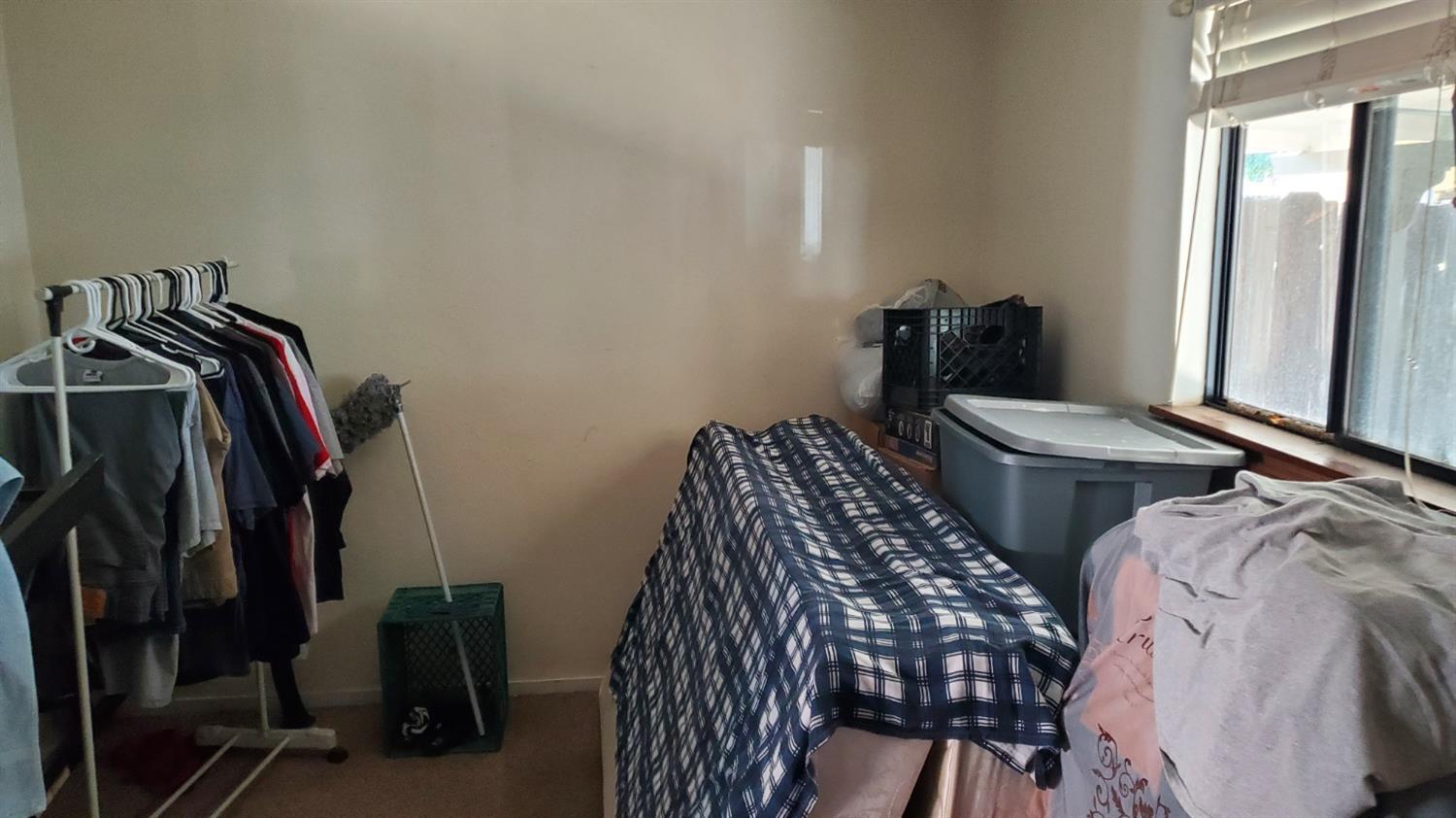 1213 M Street Reedley, CA 93654 - Photo 7 of 13 a view of walk in closet with clothes and shoes