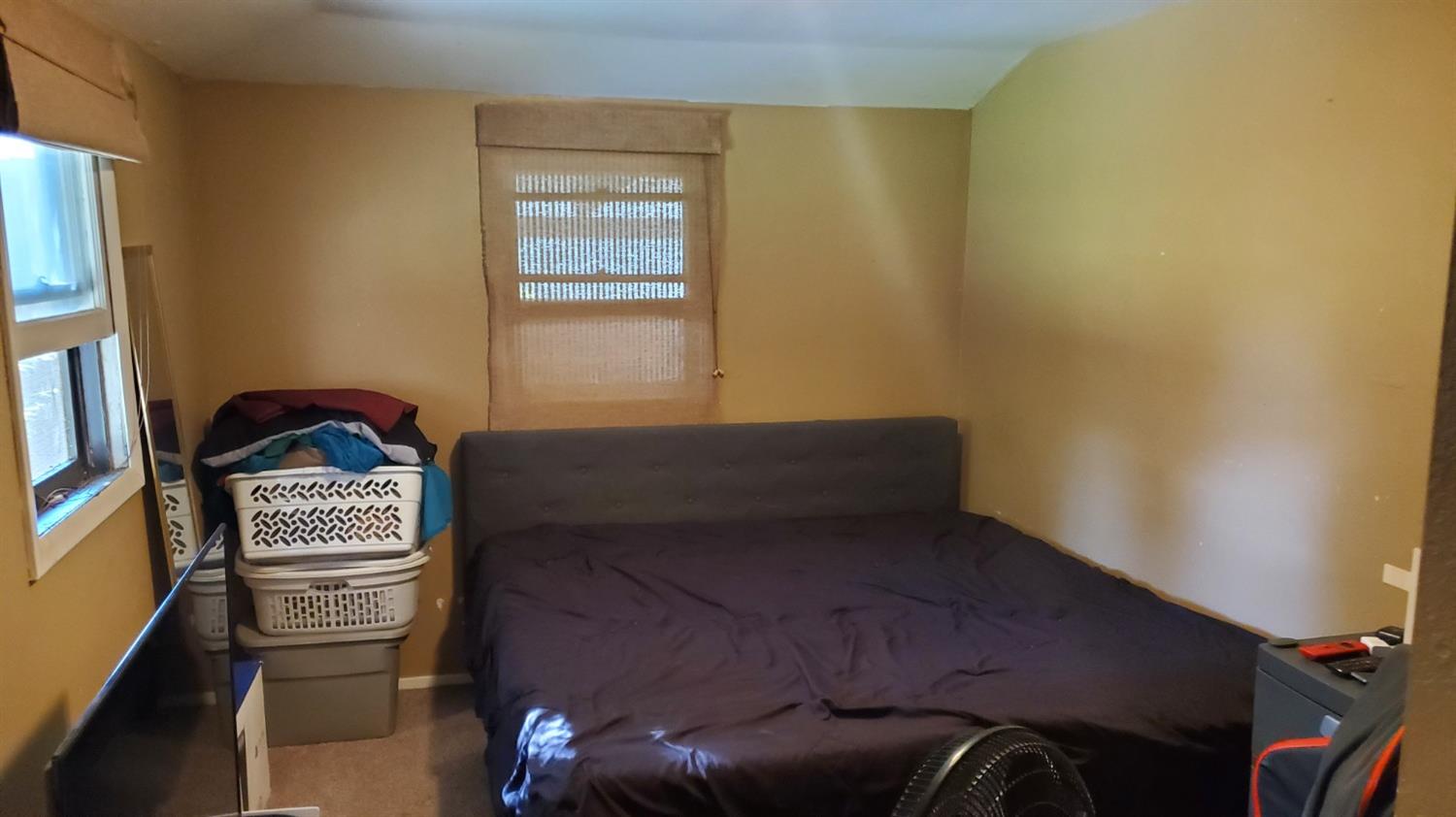 1213 M Street Reedley, CA 93654 - Photo 9 of 13 a bedroom with a bed and a window