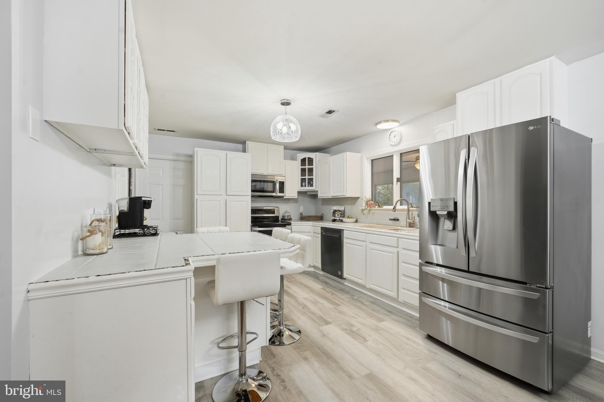 82 Sandyhook Road Berlin, MD 21811 - Photo 6 of 55 a kitchen with refrigerator cabinets and wooden floor