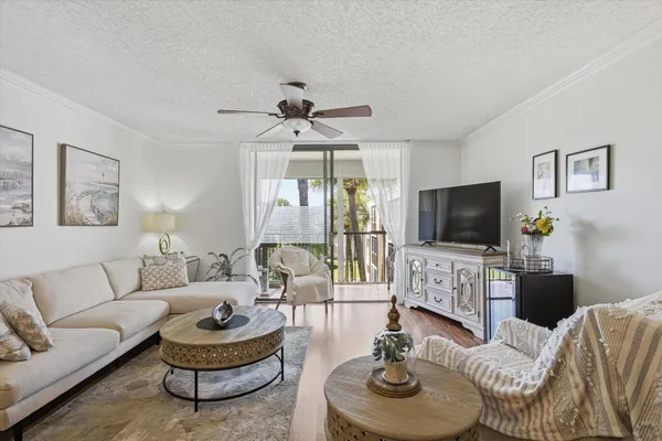 a living room with furniture a flat screen tv and a large window