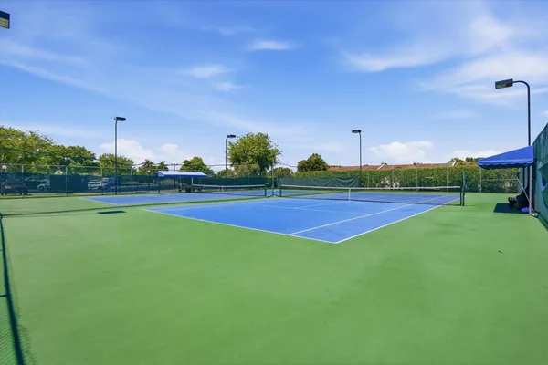 an empty room with wooden floor and outdoor kitchen view