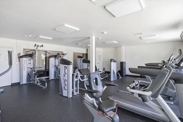 a living room with stainless steel appliances kitchen island granite countertop a stove and a sink