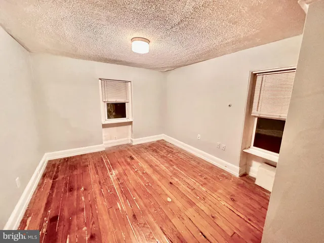 a view of empty room with wooden floor and fireplace