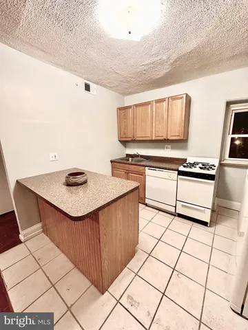 a kitchen with stainless steel appliances a stove a sink and white cabinets