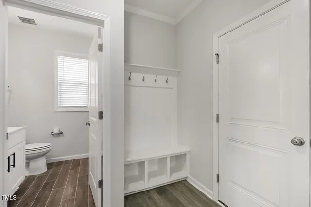a view of bathroom with toilet window and wooden floor
