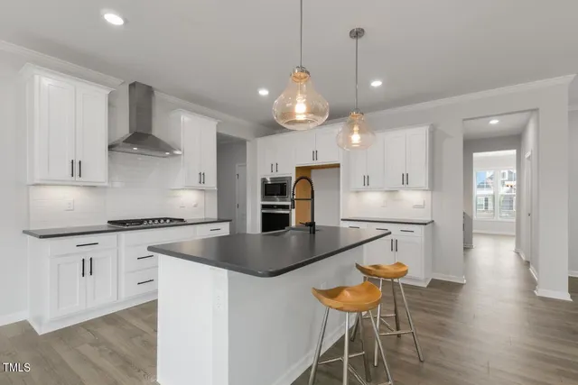 a kitchen with stainless steel appliances granite countertop a kitchen island a stove a table and chairs in it