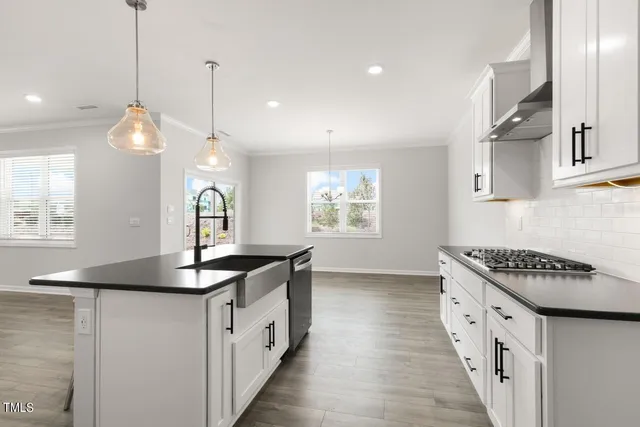 a kitchen with granite countertop a sink stove and cabinets