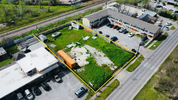 an aerial view of a tennis ground and a cars park side of the road