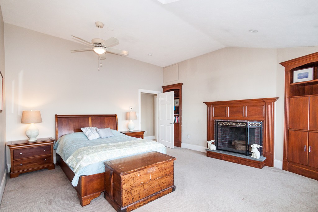 685 Jerusalem Road Cohasset, MA 02025 - Photo 19 of 29 a bedroom with a bed and a fireplace