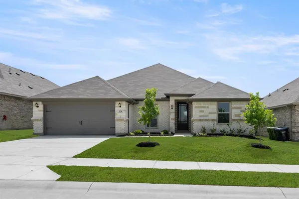 a front view of a house with a garden and yard