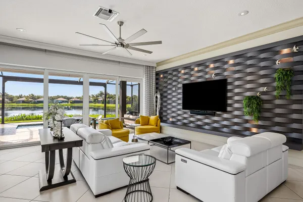 a living room with furniture a flat screen tv and a large window
