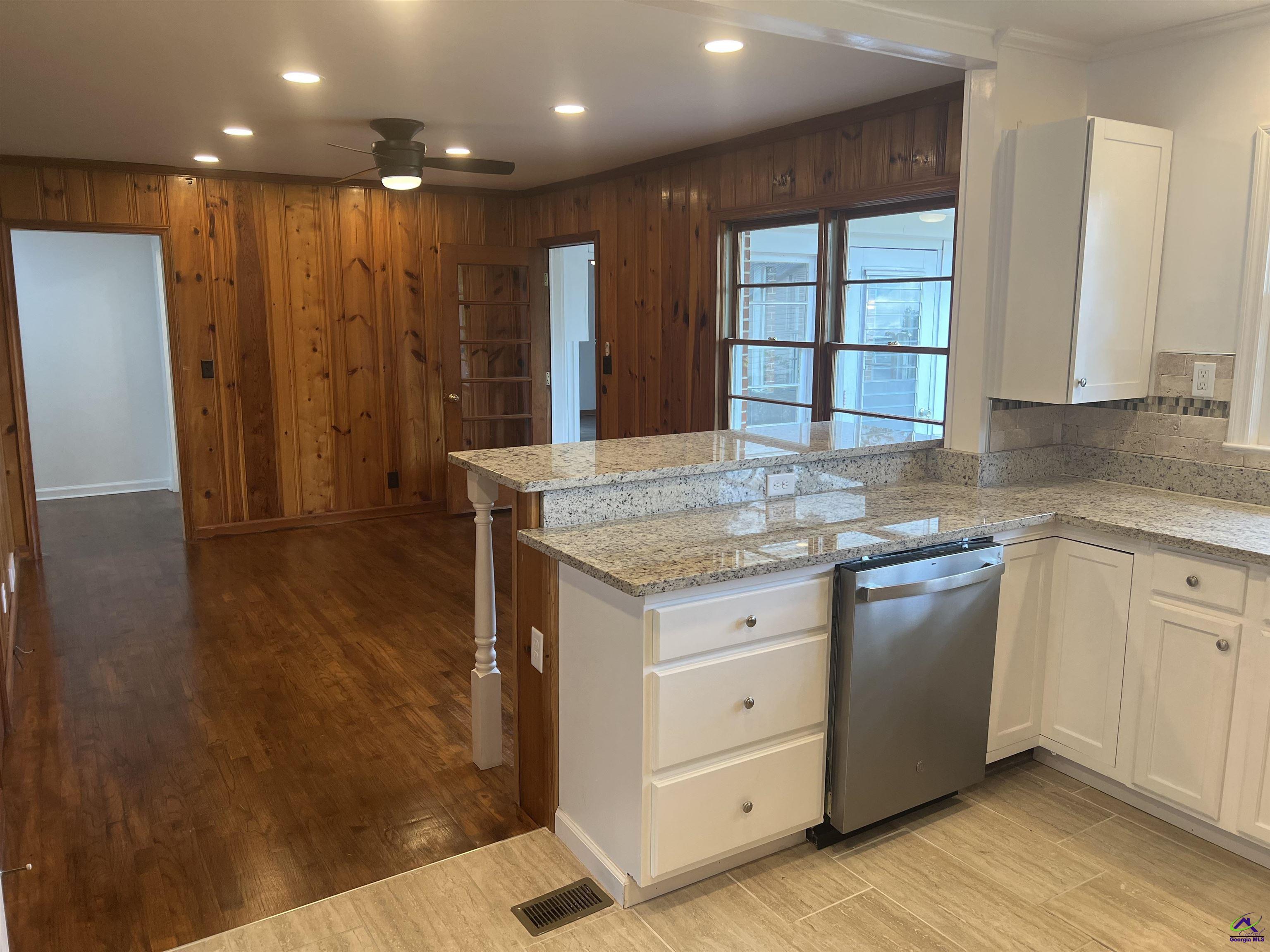 145 South 2nd Street Cochran, GA 31014 - Photo 7 of 24 a kitchen with granite countertop wooden cabinets and a counter top space