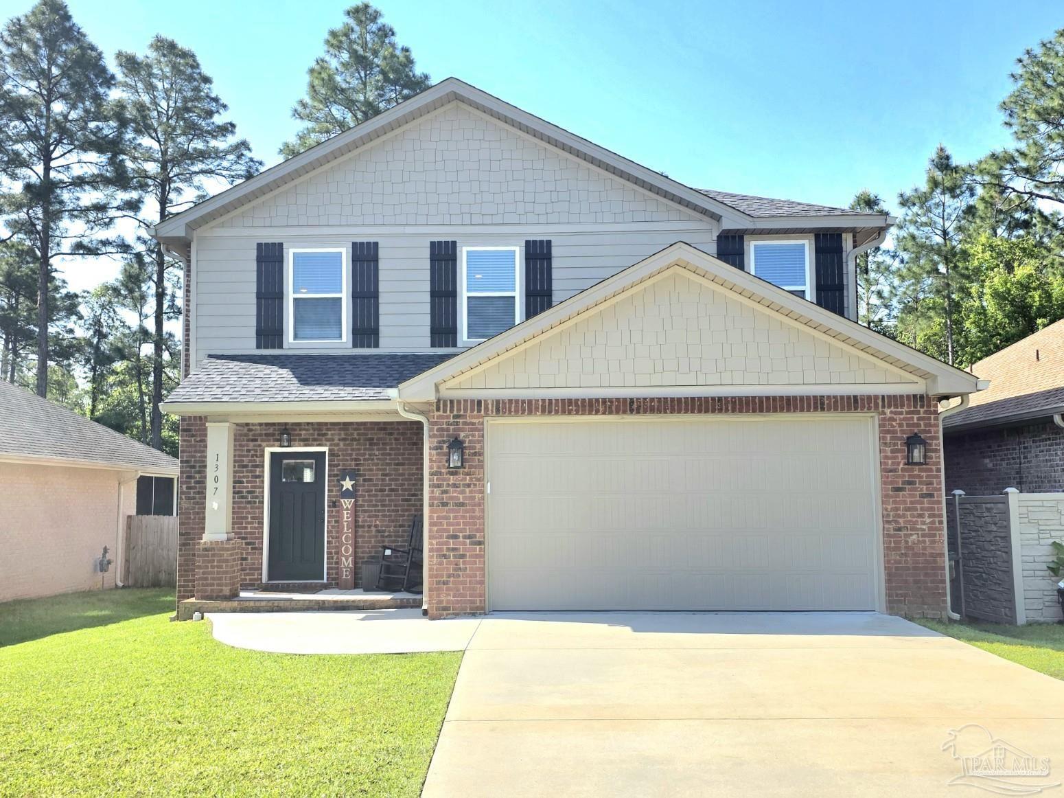 a front view of a house with a yard and garage