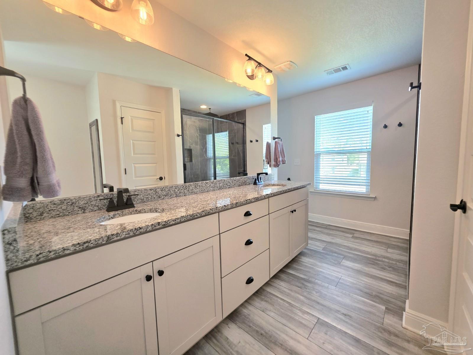 1307 Heron Inlet Pensacola, FL 32506 - Photo 15 of 35 a spacious bathroom with double vanity and a mirror