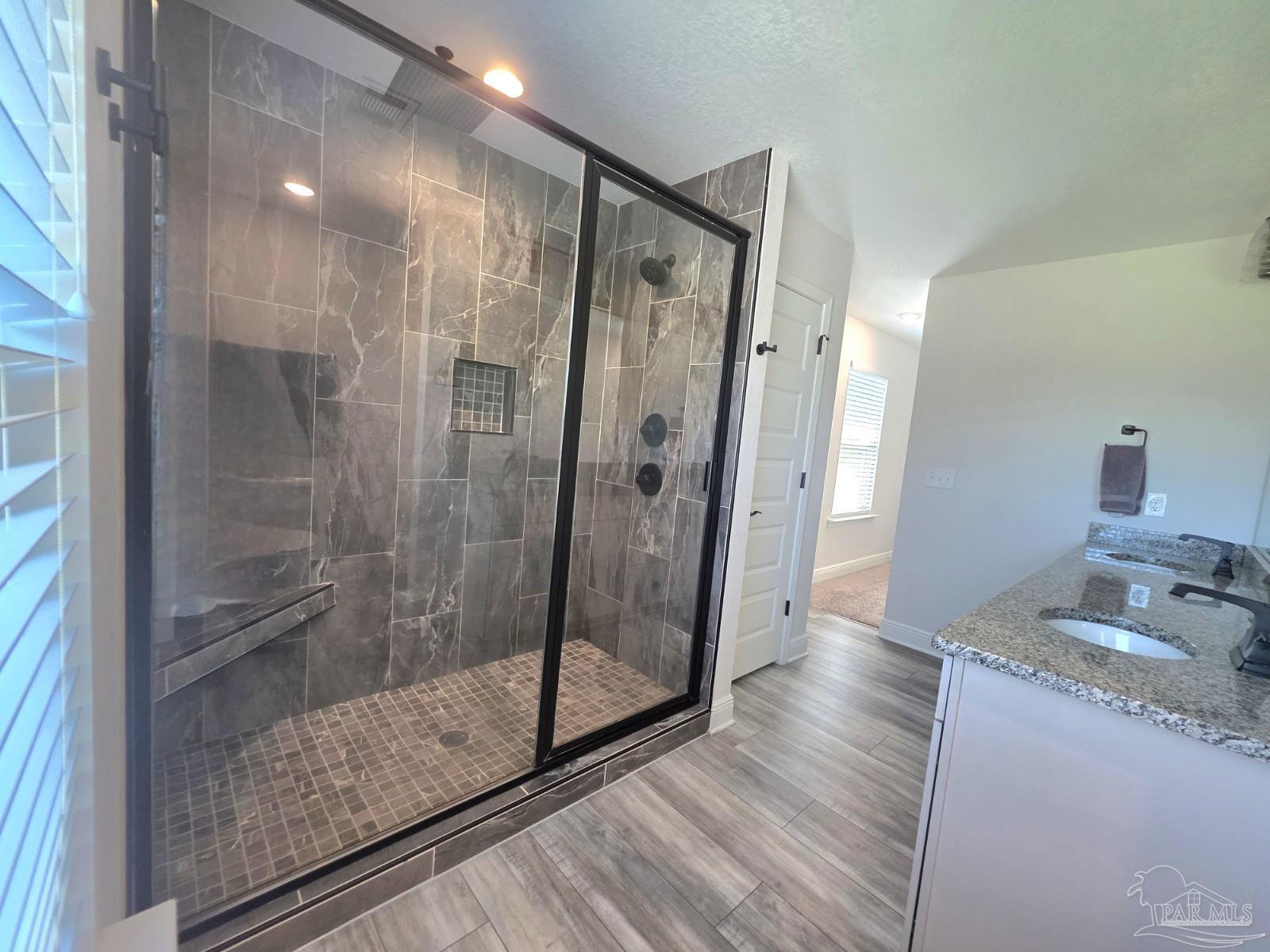 1307 Heron Inlet Pensacola, FL 32506 - Photo 16 of 35 a bathroom with a granite countertop shower a sink and a mirror
