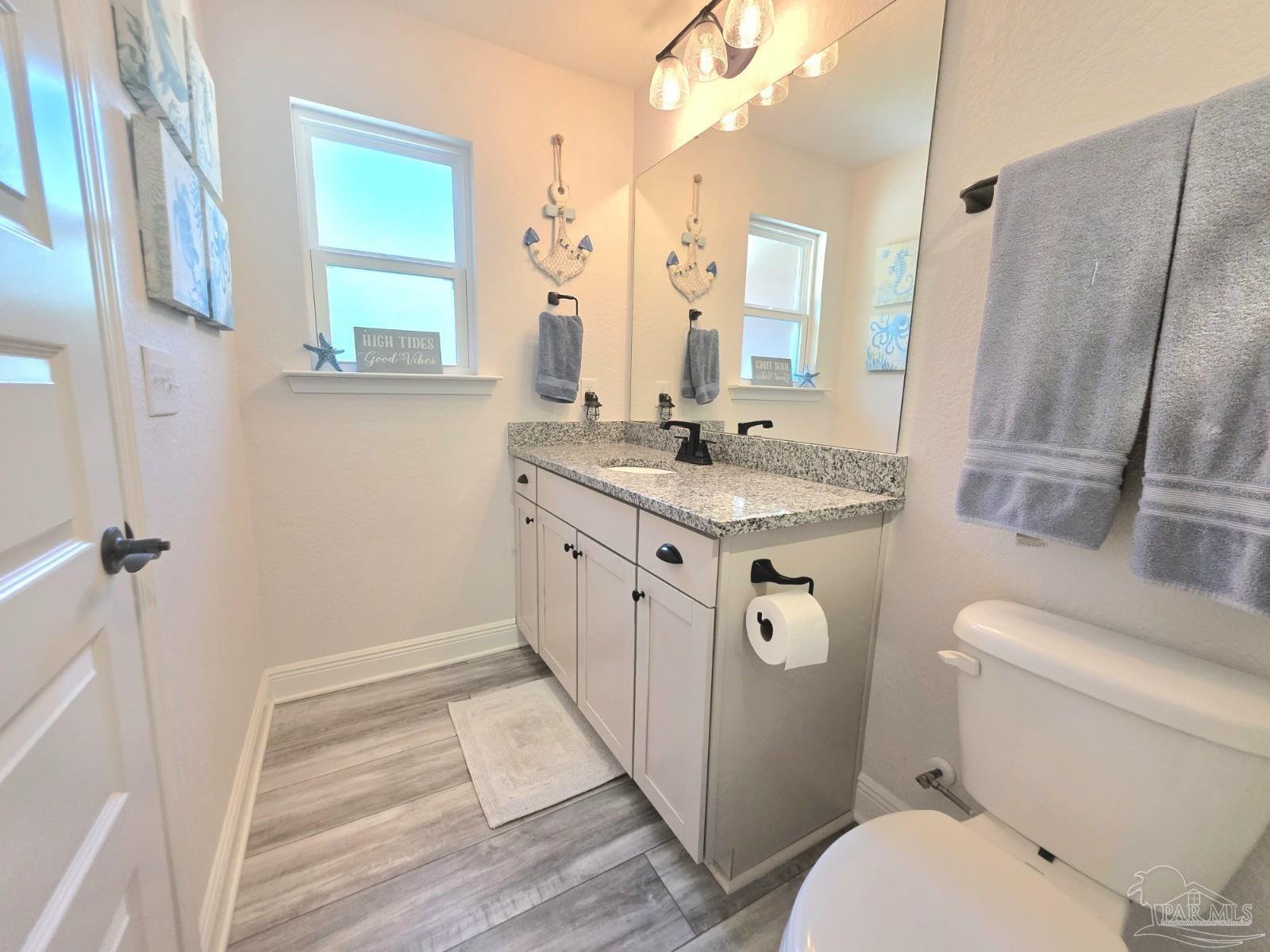 1307 Heron Inlet Pensacola, FL 32506 - Photo 22 of 35 a bathroom with a granite countertop toilet sink and mirror