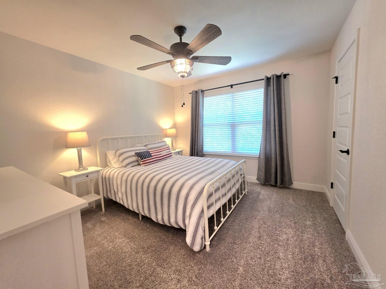 1307 Heron Inlet Pensacola, FL 32506 - Photo 24 of 35 a spacious bedroom with a bed and a large window