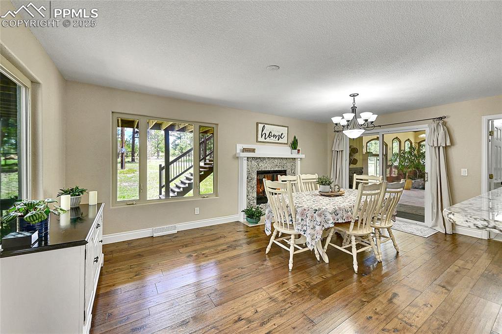 17350 Goshawk Road Colorado Springs, CO 80908 - Photo 14 of 50 a dining room with furniture a chandelier and wooden floor