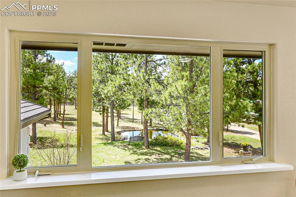 17350 Goshawk Road Colorado Springs, CO 80908 - Photo 17 of 50 a view of a room that has a large window and wooden floor