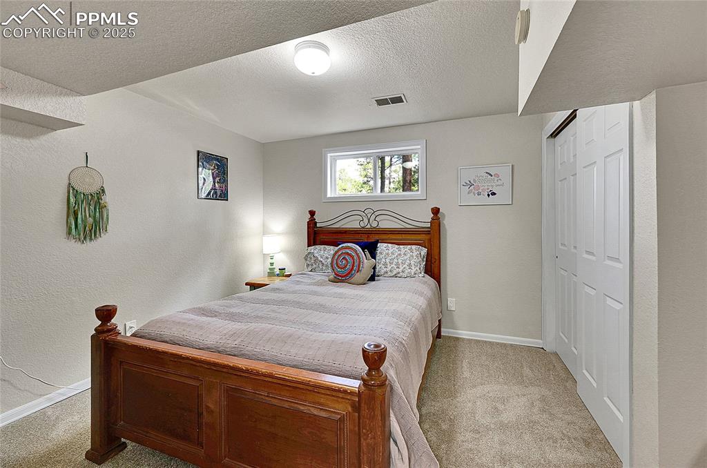 17350 Goshawk Road Colorado Springs, CO 80908 - Photo 28 of 50 a bedroom with a bed and a window
