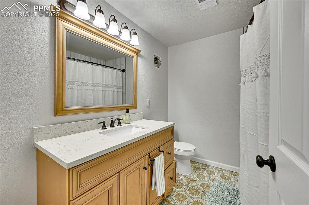 17350 Goshawk Road Colorado Springs, CO 80908 - Photo 29 of 50 a bathroom with a sink a toilet and a mirror