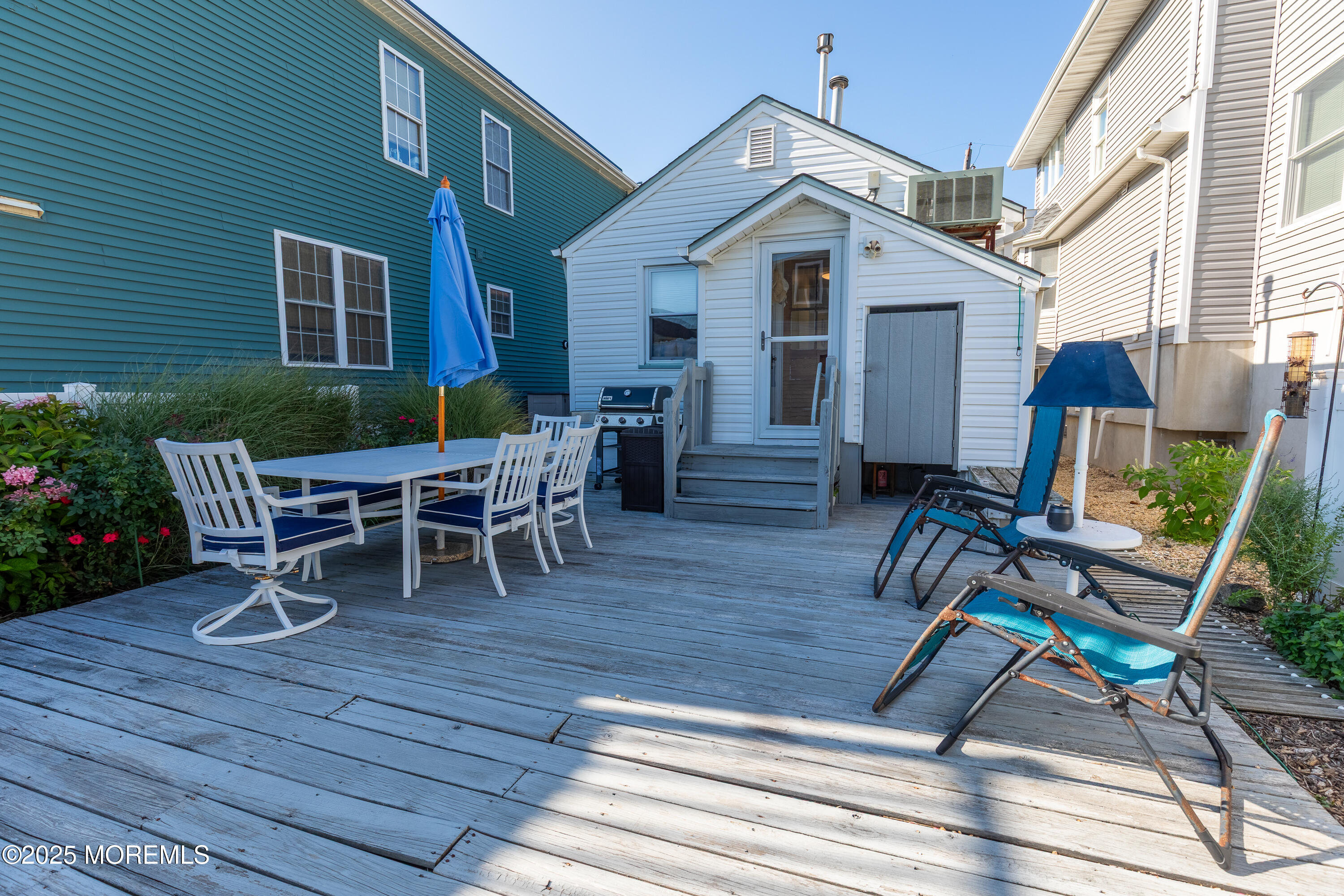 121 L Street Seaside Park, NJ 08752 - Photo 22 of 37 a view of a house with wooden chairs and table in a patio