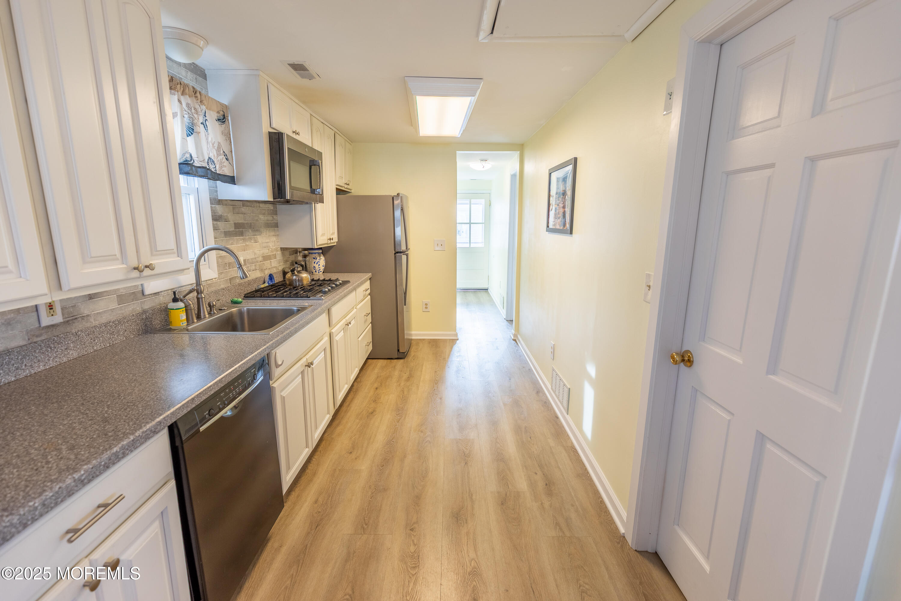 121 L Street Seaside Park, NJ 08752 - Photo 9 of 37 a kitchen with granite countertop a sink stove refrigerator and cabinets