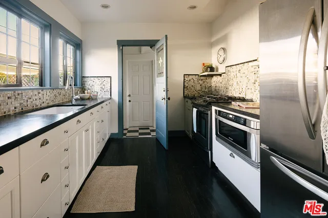 a kitchen with stainless steel appliances kitchen island granite countertop a stove and a refrigerator