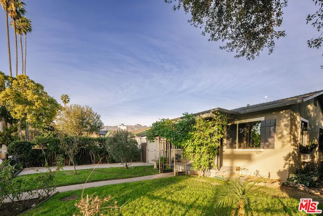 a view of a house with a big yard and a large tree