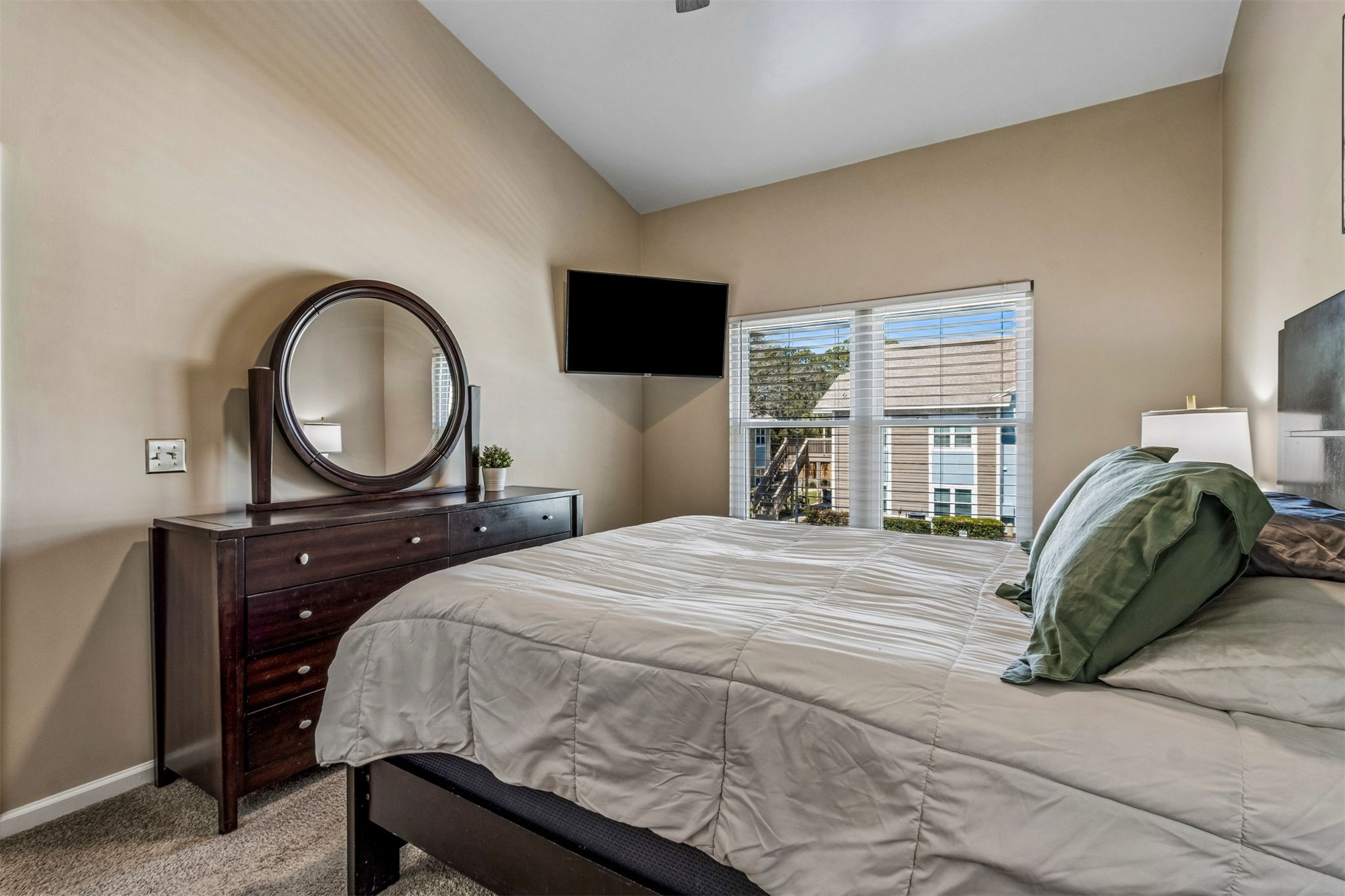 1601 Nectarine Street, Unit A6 Fernandina Beach, FL 32034 - Photo 18 of 40 a bedroom with a bed a mirror and a flat tv screen on the dresser