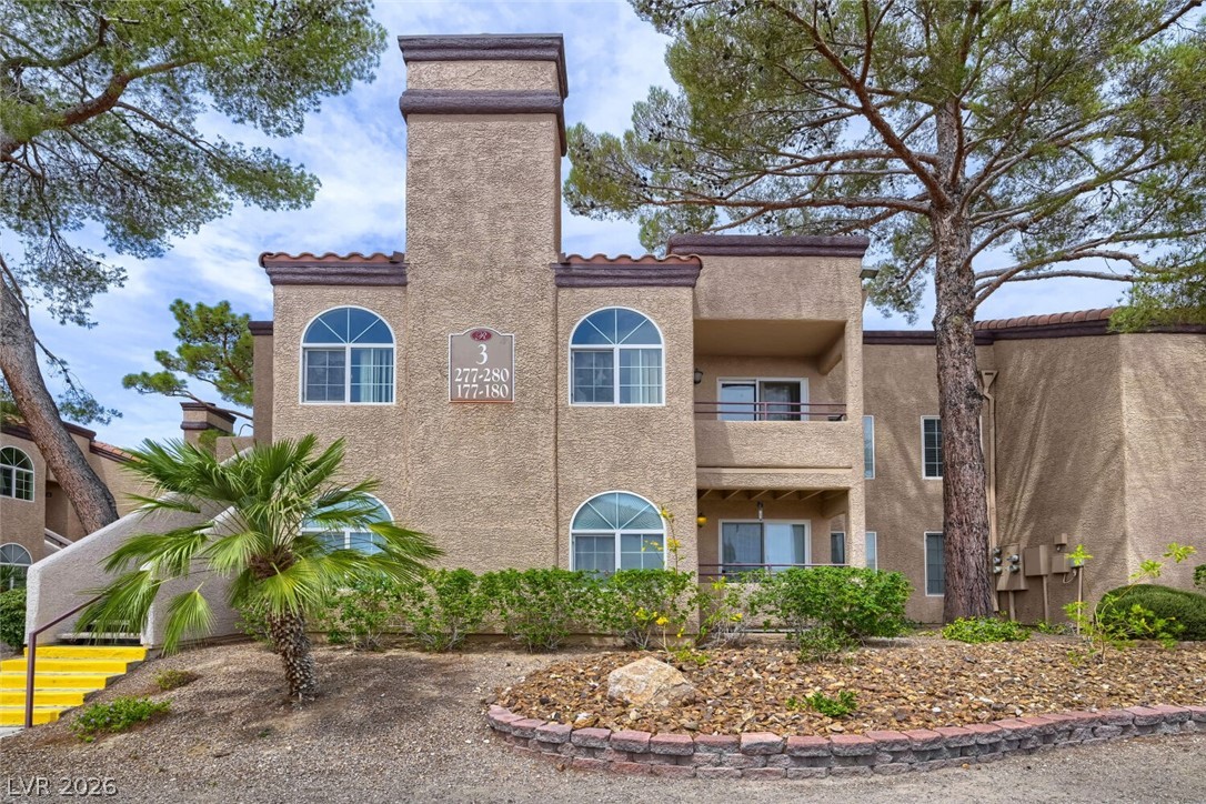 9325 West Desert Inn Road, Unit 177 Las Vegas, NV 89117 - Photo 3 of 24 A desert-inspired multi-level structure offers balconies and arched windows amidst mature trees and tasteful landscaping.