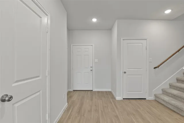 a view of a hallway with wooden floor and entryway