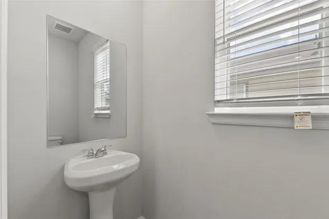 a bathroom with a sink a mirror and a window
