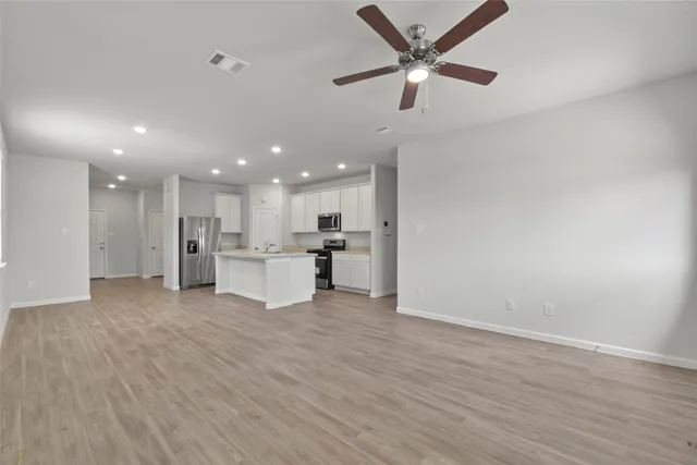 a view of an empty room with wooden floor