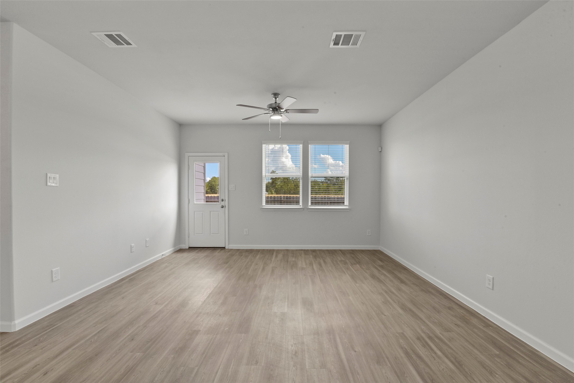 20811 Adventure Way Porter, TX 77365 - Photo 5 of 28 an empty room with wooden floor chandelier fan and windows