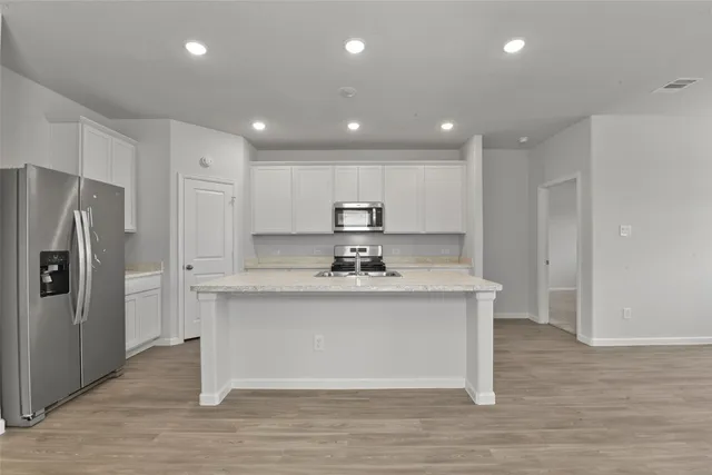 a view of kitchen with stainless steel appliances granite countertop cabinets and wooden floor