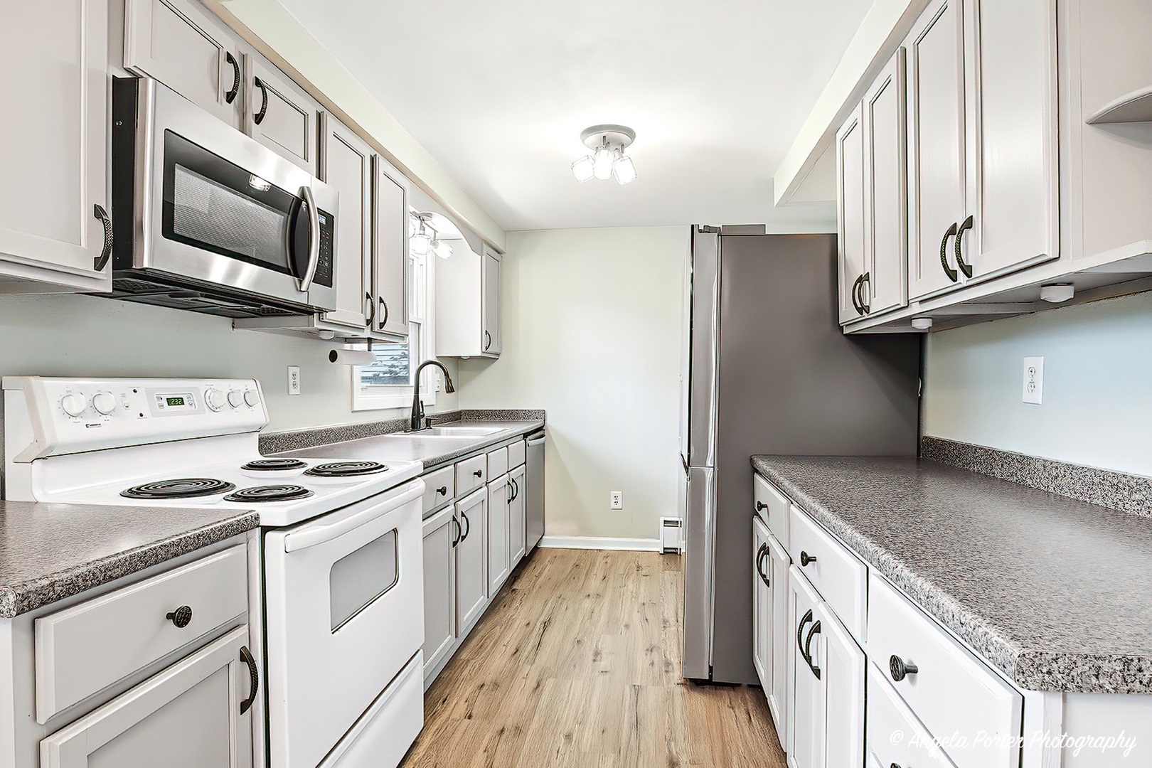 5703 Fox Lake Road McHenry, IL 60051 - Photo 3 of 20 a kitchen with stainless steel appliances granite countertop a stove a sink and a microwave