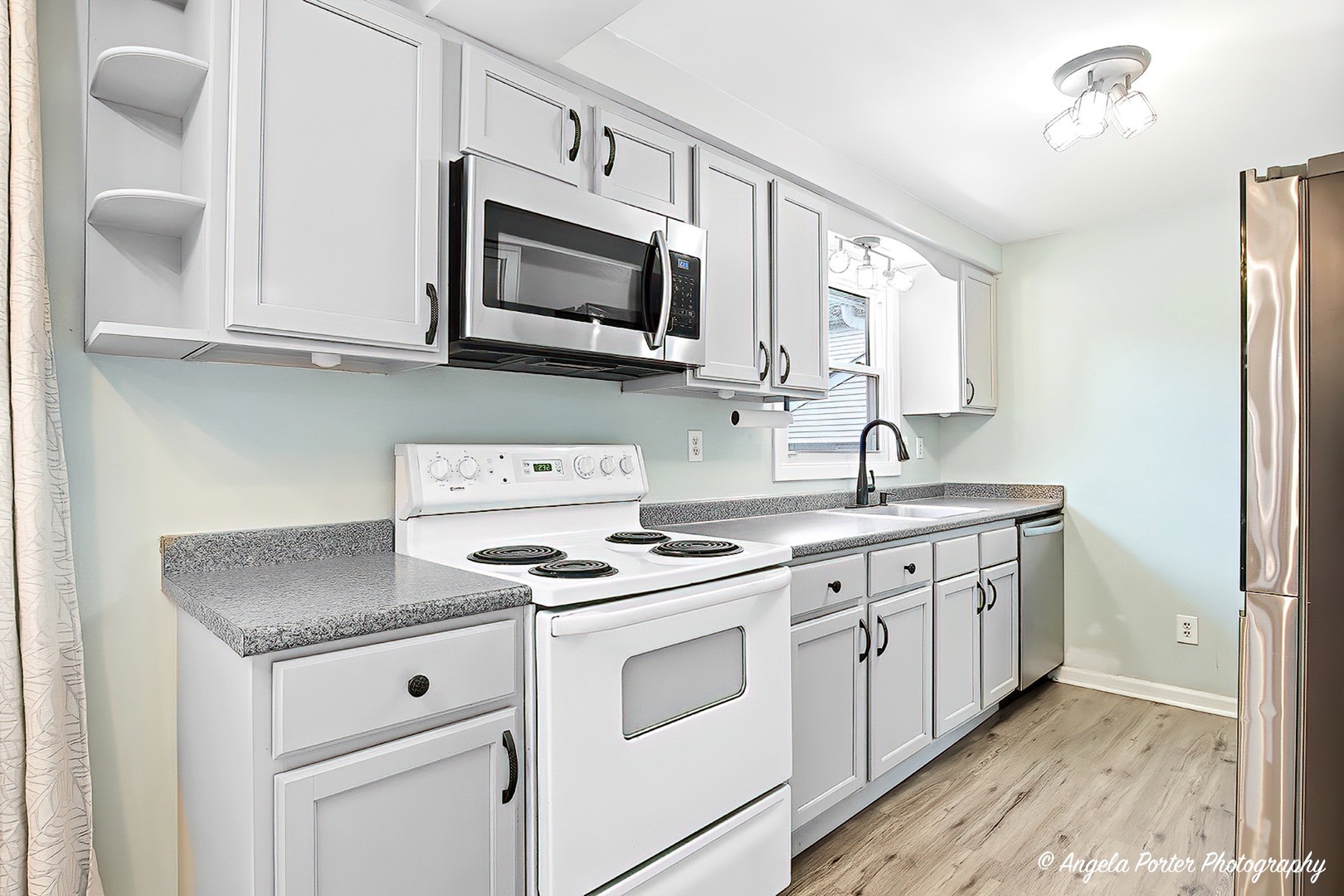 5703 Fox Lake Road McHenry, IL 60051 - Photo 4 of 20 a kitchen with white cabinets stainless steel appliances and sink