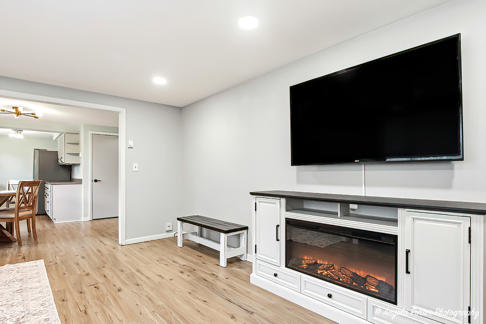 5703 Fox Lake Road McHenry, IL 60051 - Photo 9 of 20 a living room with a flat screen tv a fireplace and a flat screen tv