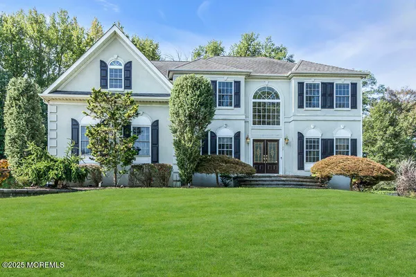 a front view of a house with a yard and trees