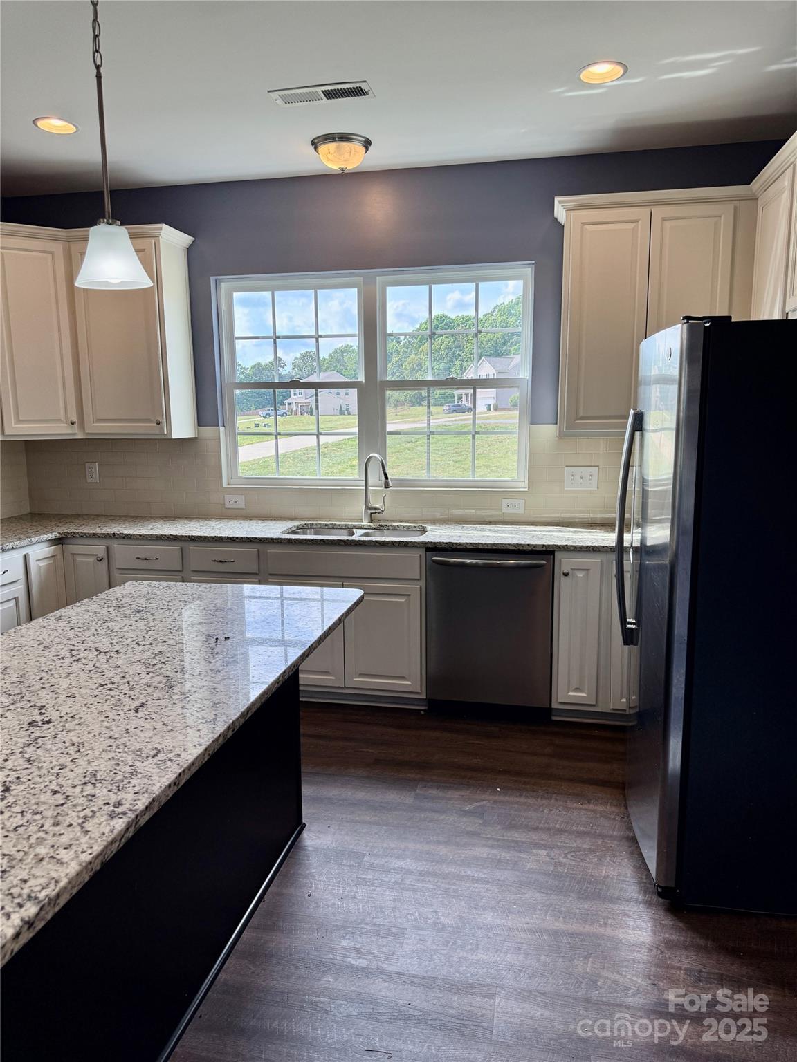 4048 Avis Way Monroe, NC 28110 - Photo 7 of 23 a kitchen with stainless steel appliances granite countertop a sink window and wooden floor